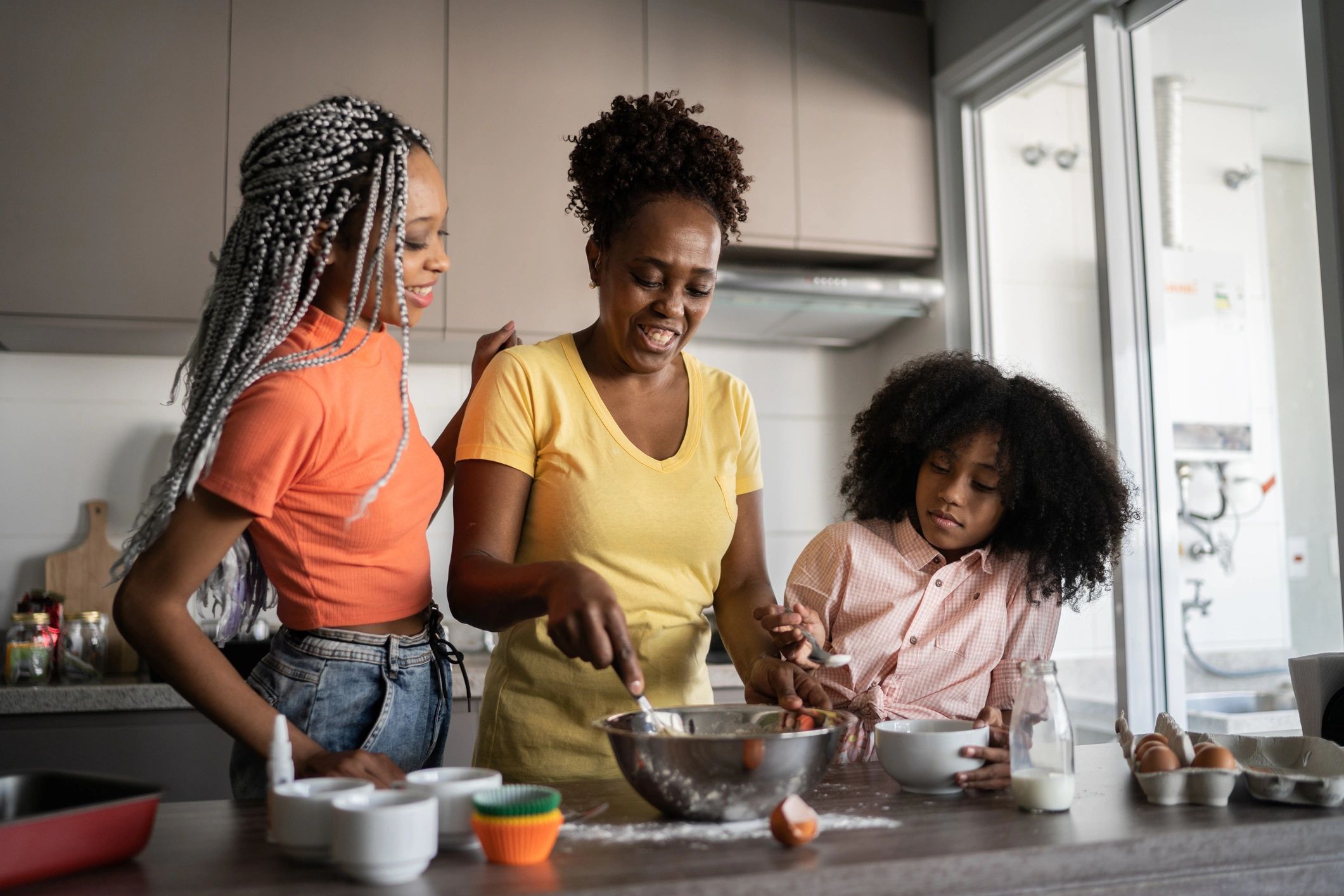 Black mother and daughters cooking together at home