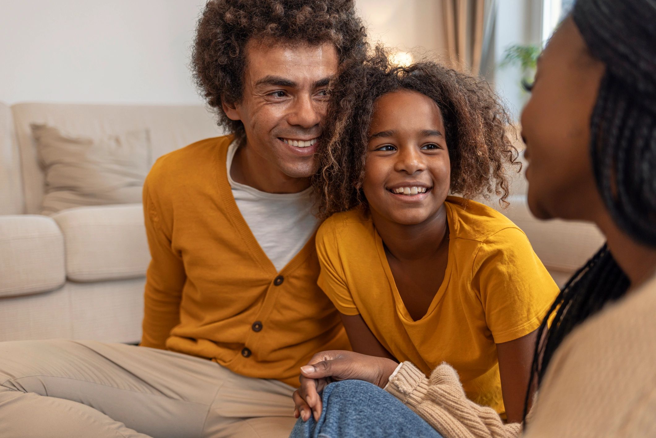 Black parents relaxing and talking with their daughter