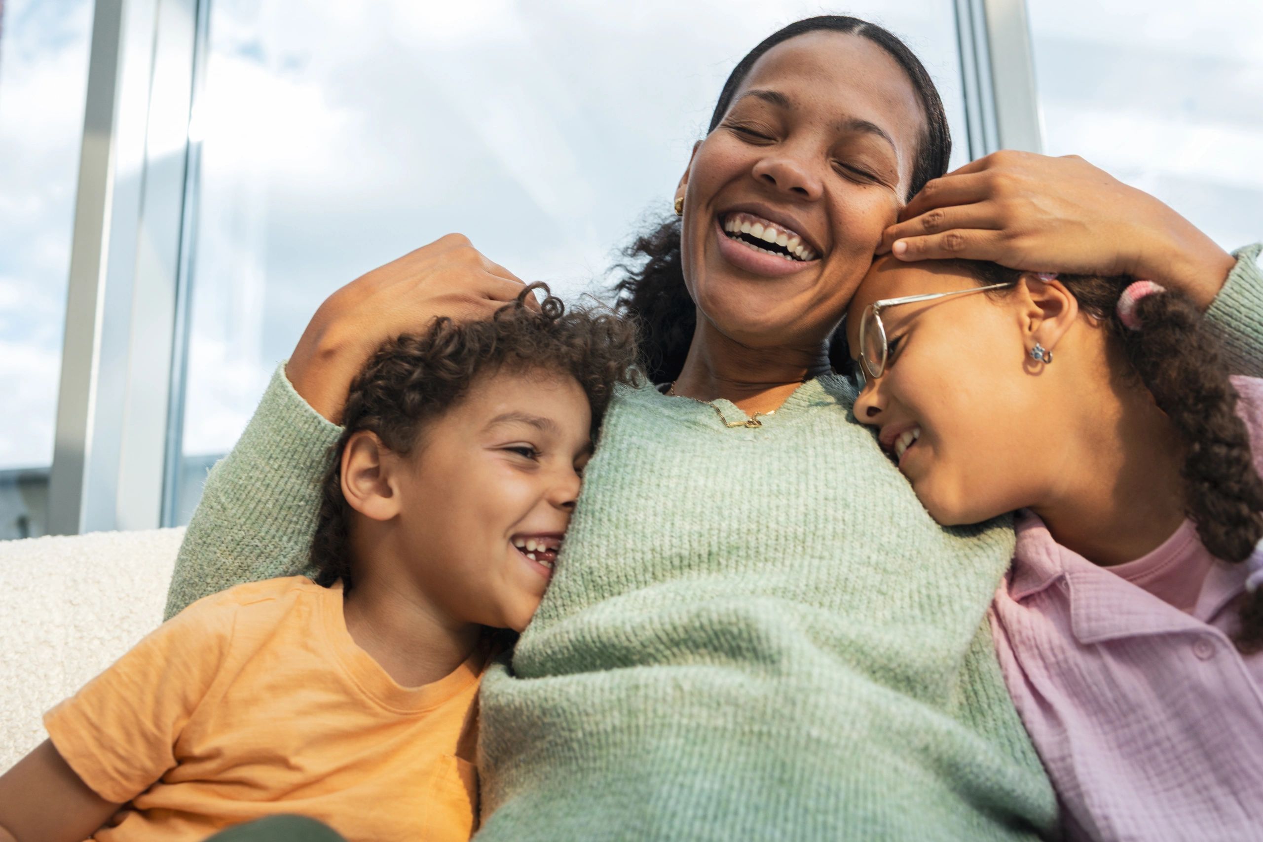 Happy Black family laughing and hugging at home