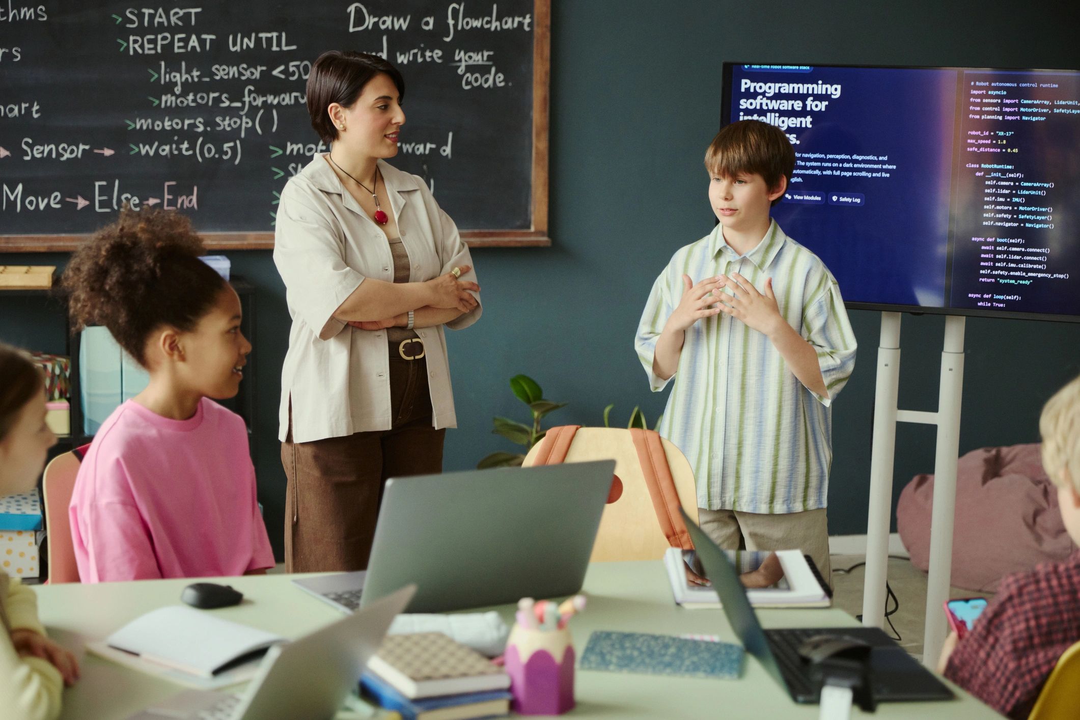 Teenage boy presenting coding project in classroom workshop